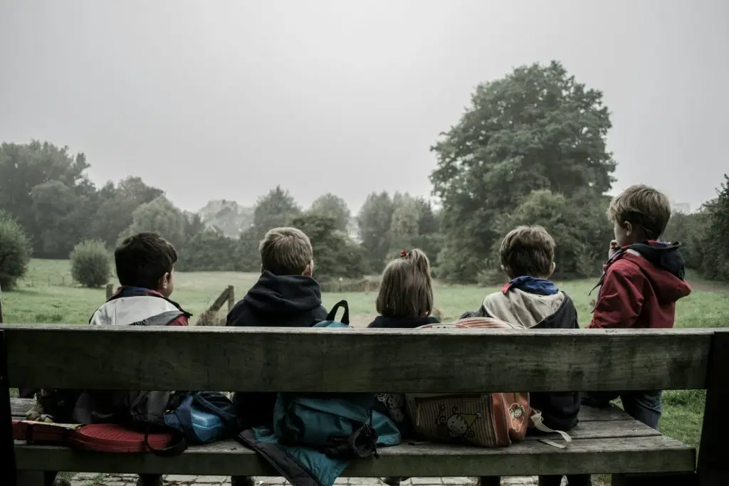 Foto einiger Grundschulkinder auf einer Bank.